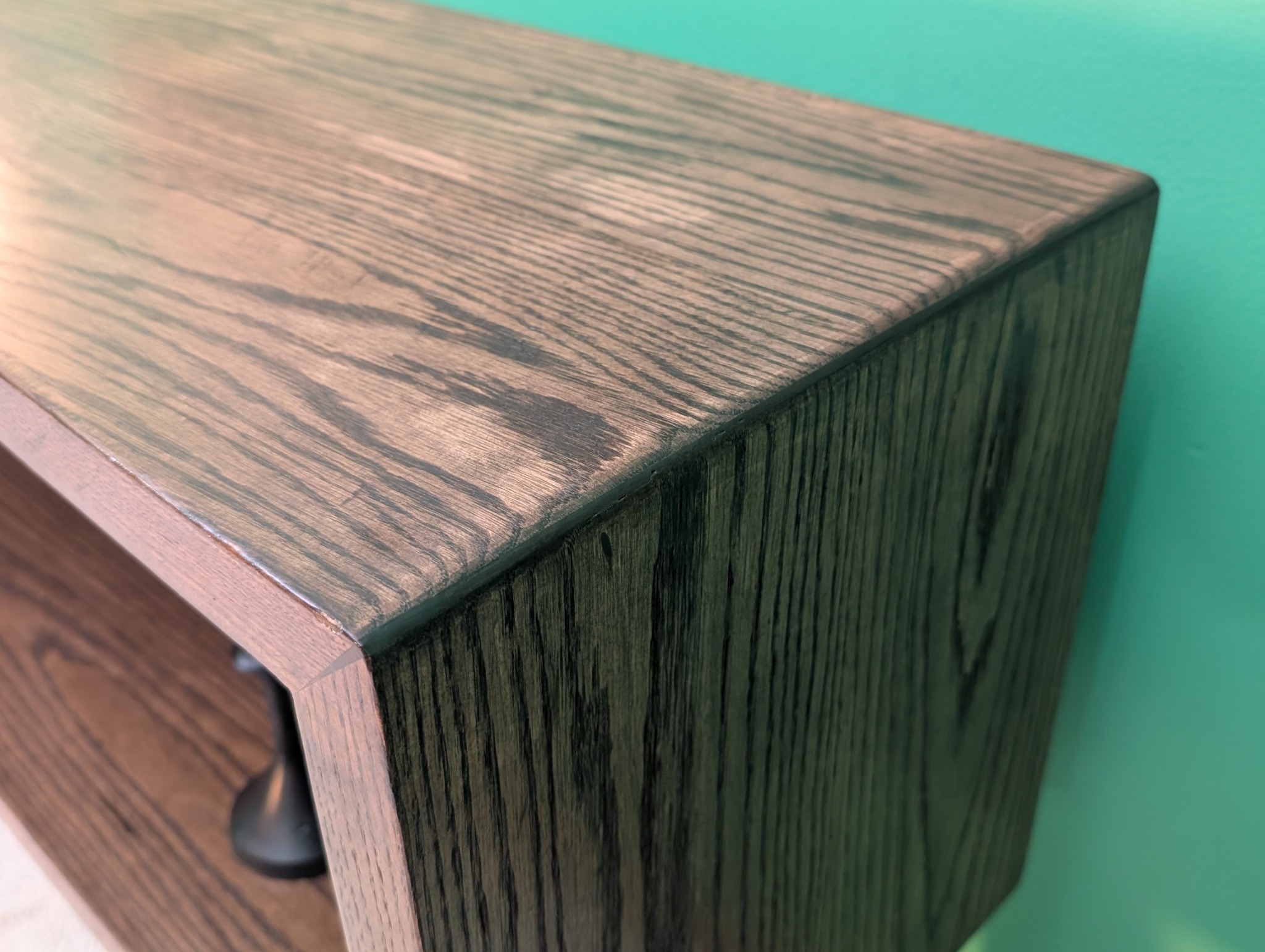 Close view of the console’s mitered corner and matched oak grain