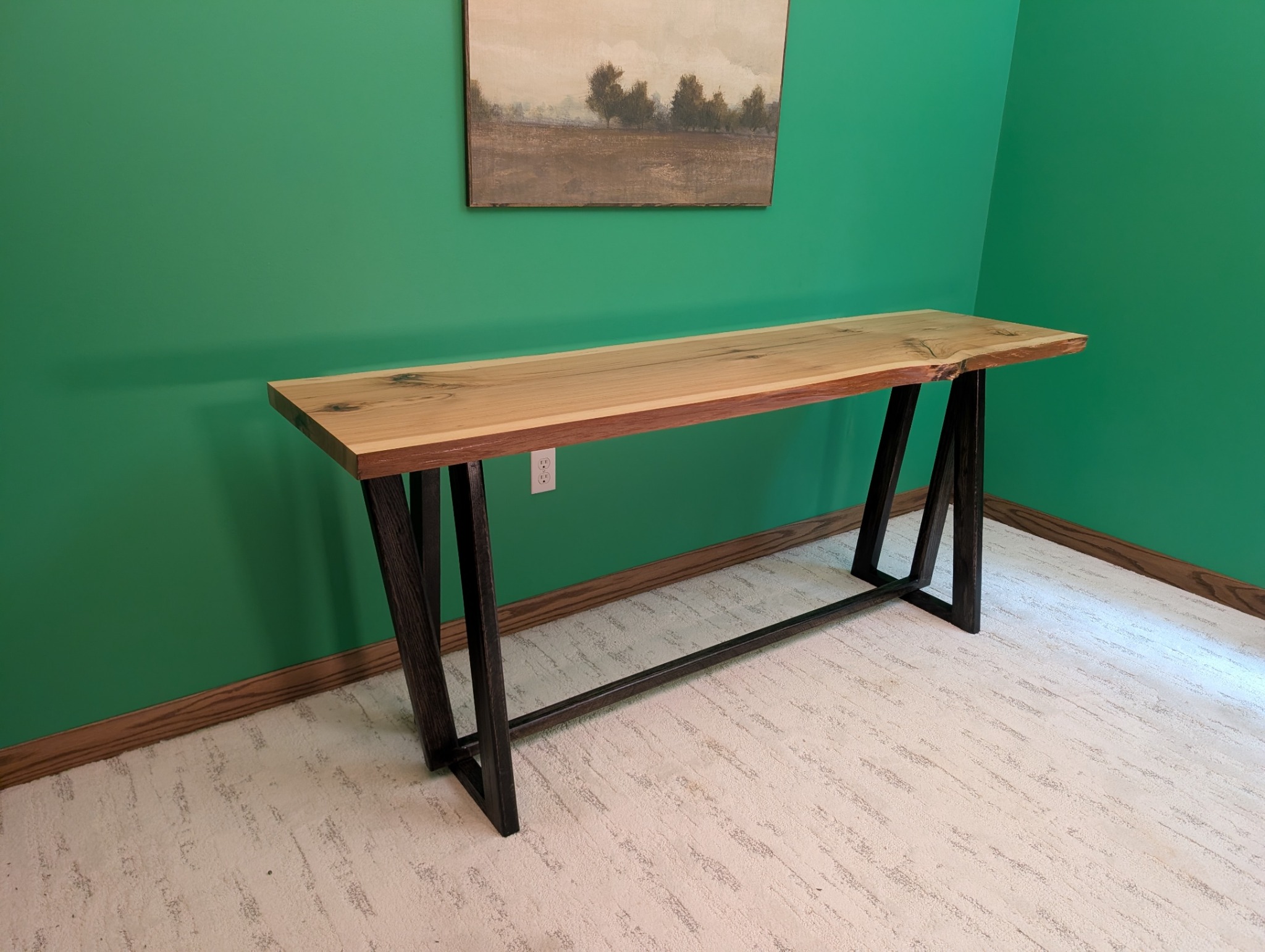 Three-quarter view showing the hickory slab and geometric base
